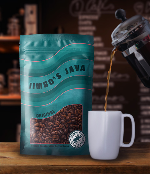 A teal stand-up pouch labeled Jimbo's Java, Original, Medium Roast Arabica Coffee Beans with a clear window showing whole coffee beans, sitting on a wooden counter beside a mug being filled from a French press in a café setting.